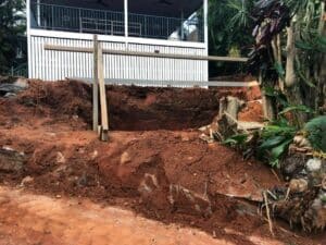 House Under Construction, Surrounded By A Wooden Fence On A Dirt Lot — Tropical Prestige Pools in Kuranda, QLD